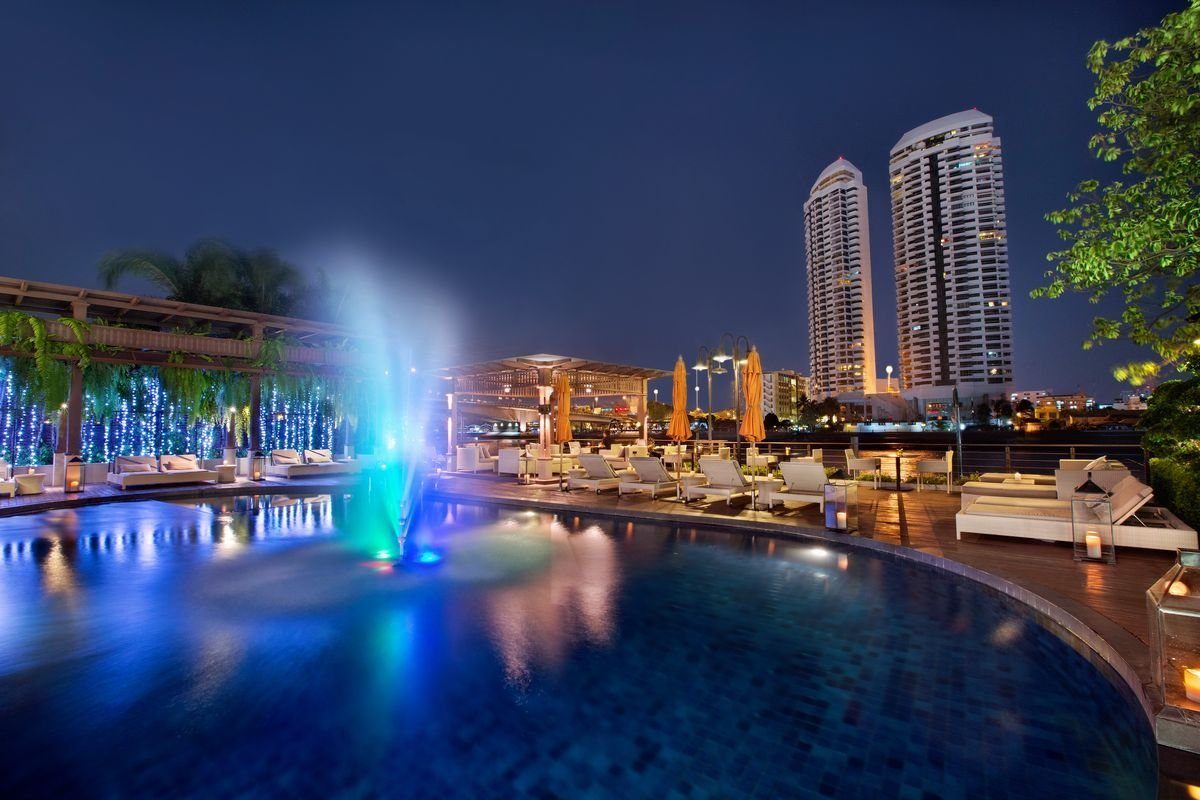 Riverside pool at night — Riva Surya Bangkok