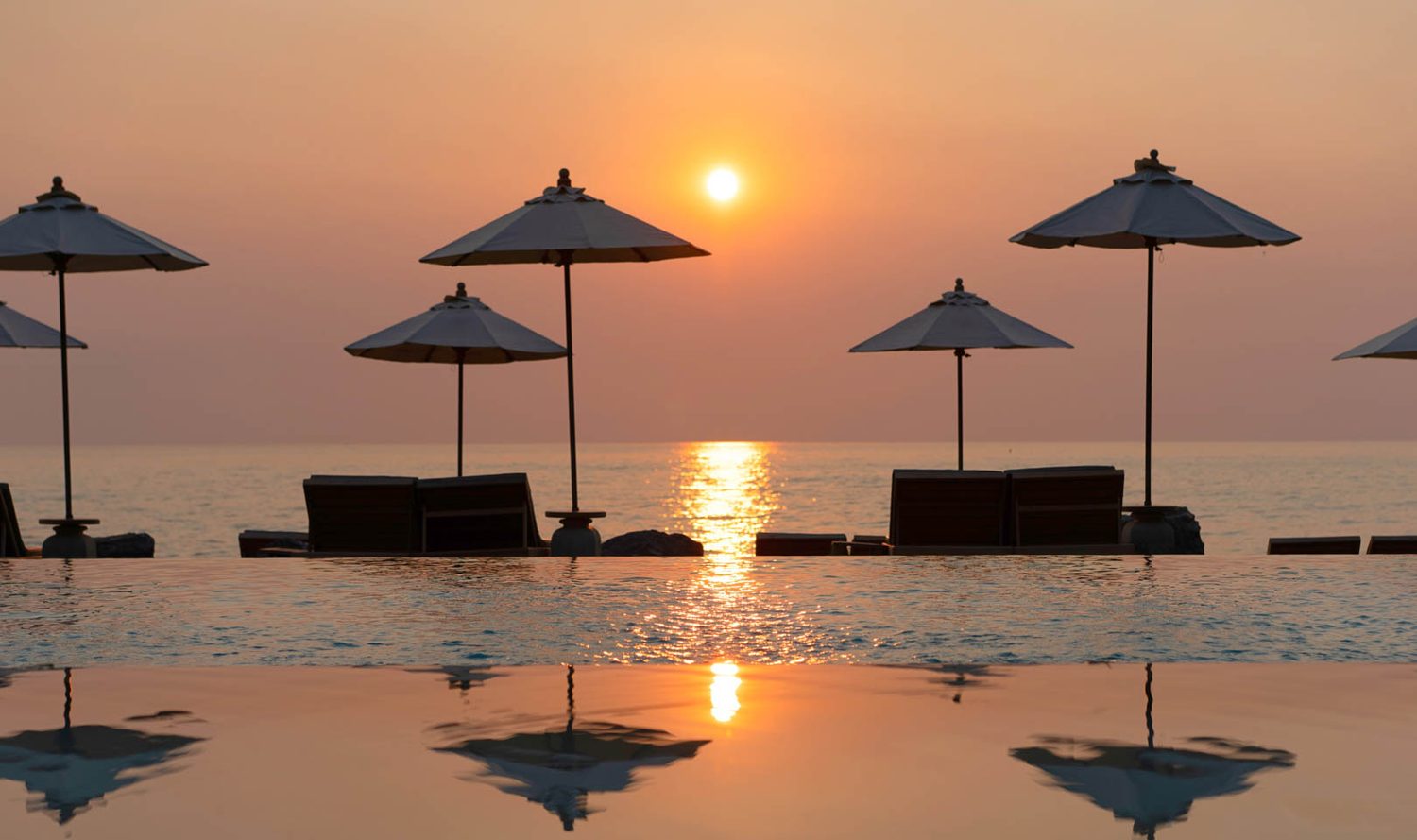 Infinity pool at sunset — Devasom Hua Hin Resort