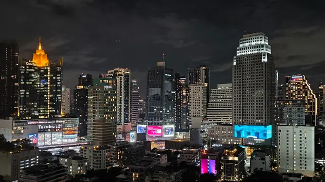 Palmiers et toits bas sous un ciel voilé sur la côte de Phuket