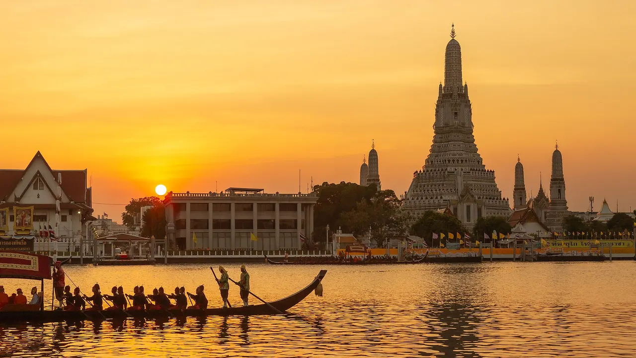 Royal barges on the Chao Phraya River in Bangkok with Wat Arun in the background