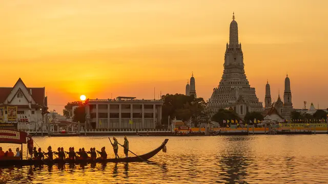 Royal barges on the Chao Phraya River in Bangkok with Wat Arun in the background