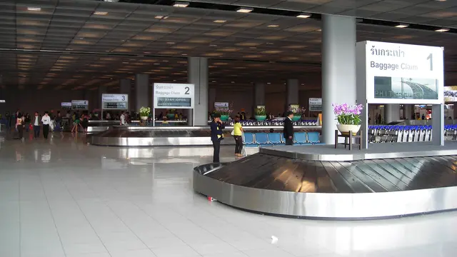 Suitcases on a baggage carousel in an airport arrivals hall